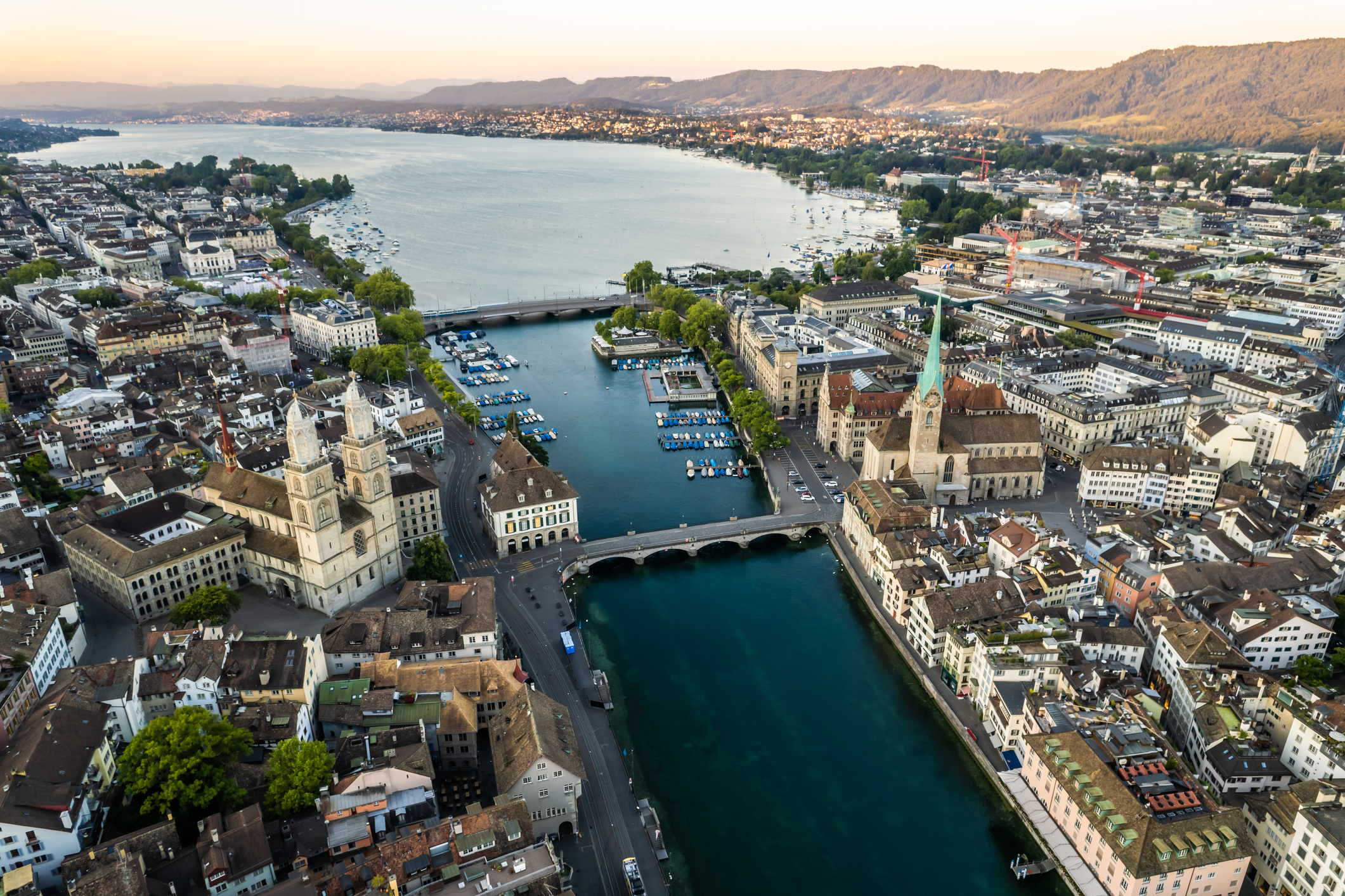 Aerial drone shot flying above Lake Zurich, Switzerland in sunny day. Beautiful landscape of a large magnificent lake and natural mountain scenery that popular place in summer in the city of Zurich.